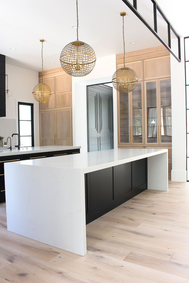 https://thehouseofsilverlining.com/wp-content/uploads/2018/05/modern-kitchen-black-shaker-style-inset-rift-sawn-white-oak-cabinets-waterfall-quartz-double-islands-steel-transom-10.jpg