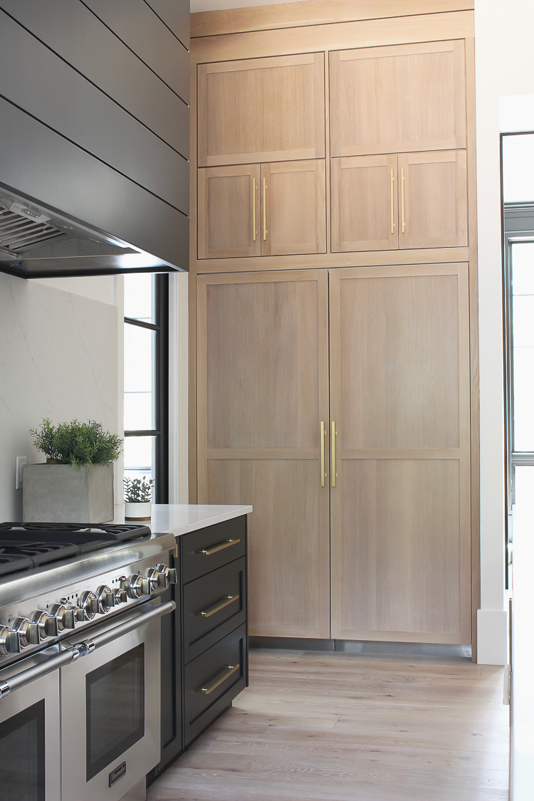 Modern kitchen with rift sawn white oak cabinet panels on built in refrigerator freezer