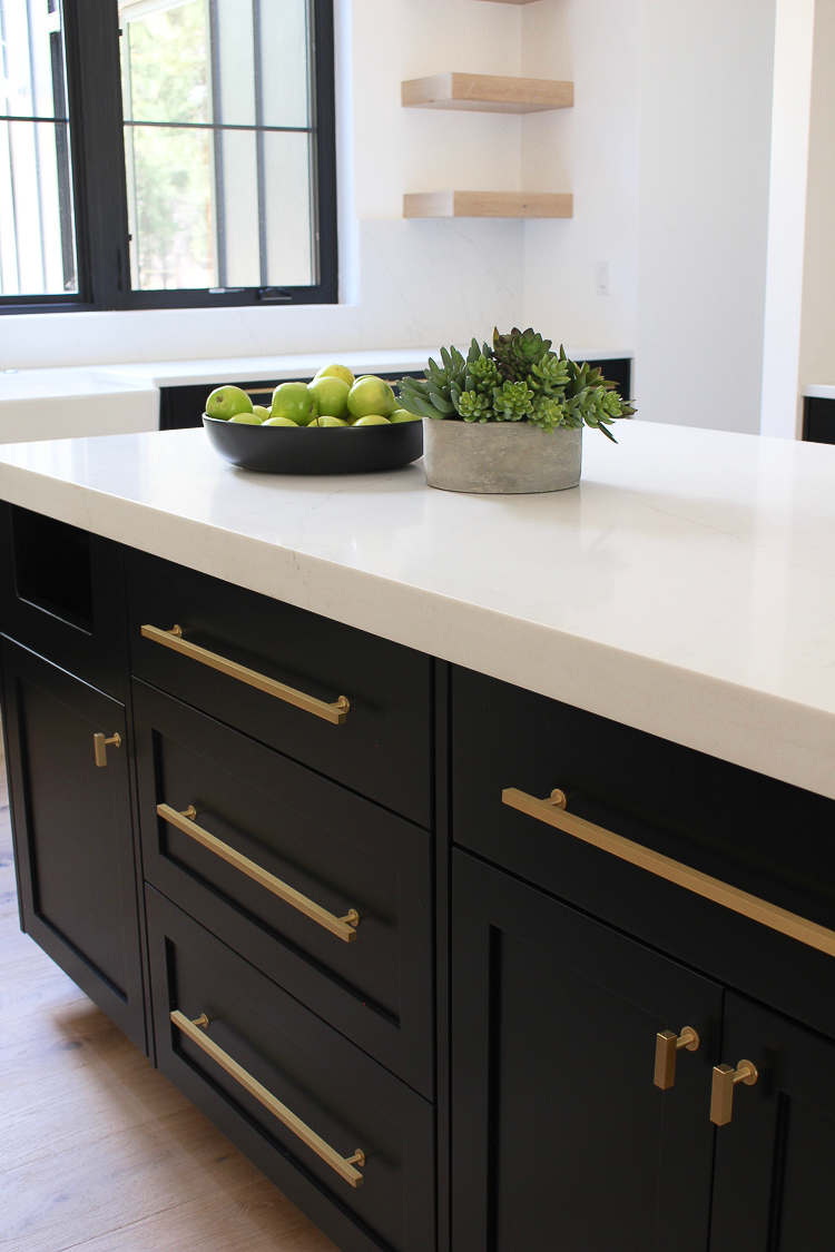 Black shaker style inset cabiets with white quartz gold hardware