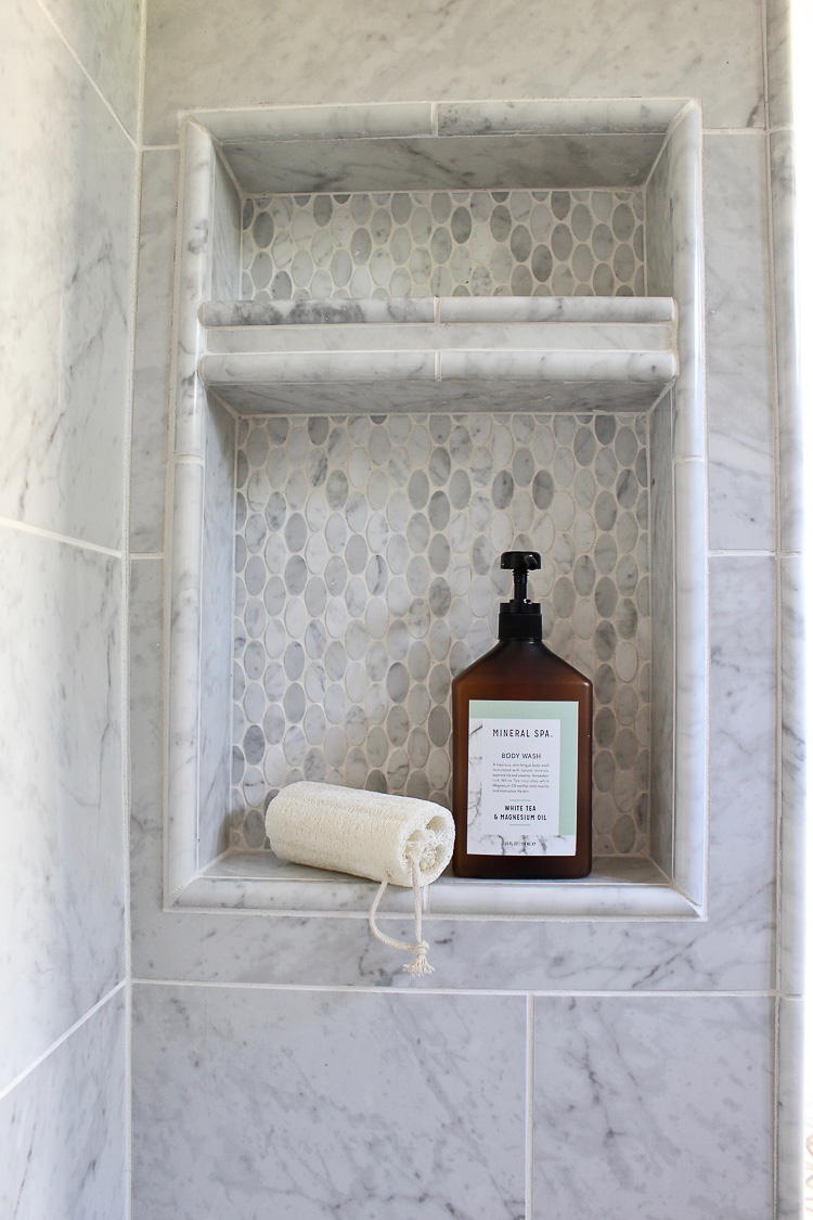 Modern bathroom with white oak cabinets, zero entry marble shower, brass fixtures