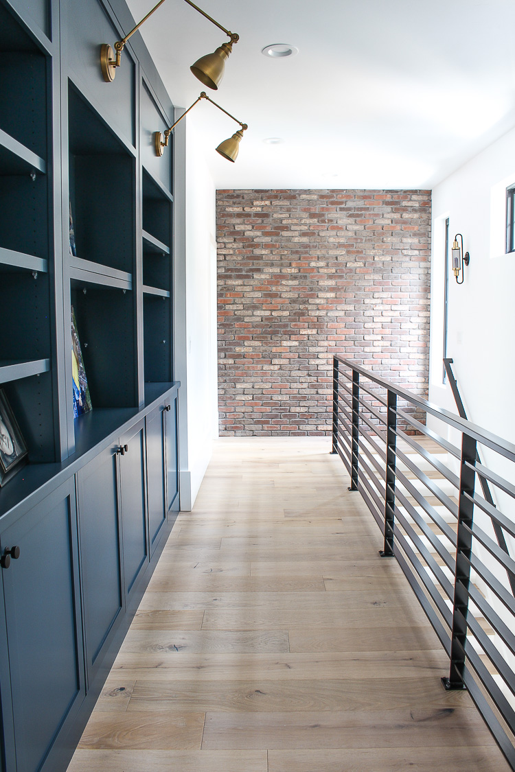 industrial brick wall, steel railing, dark blue cabinets