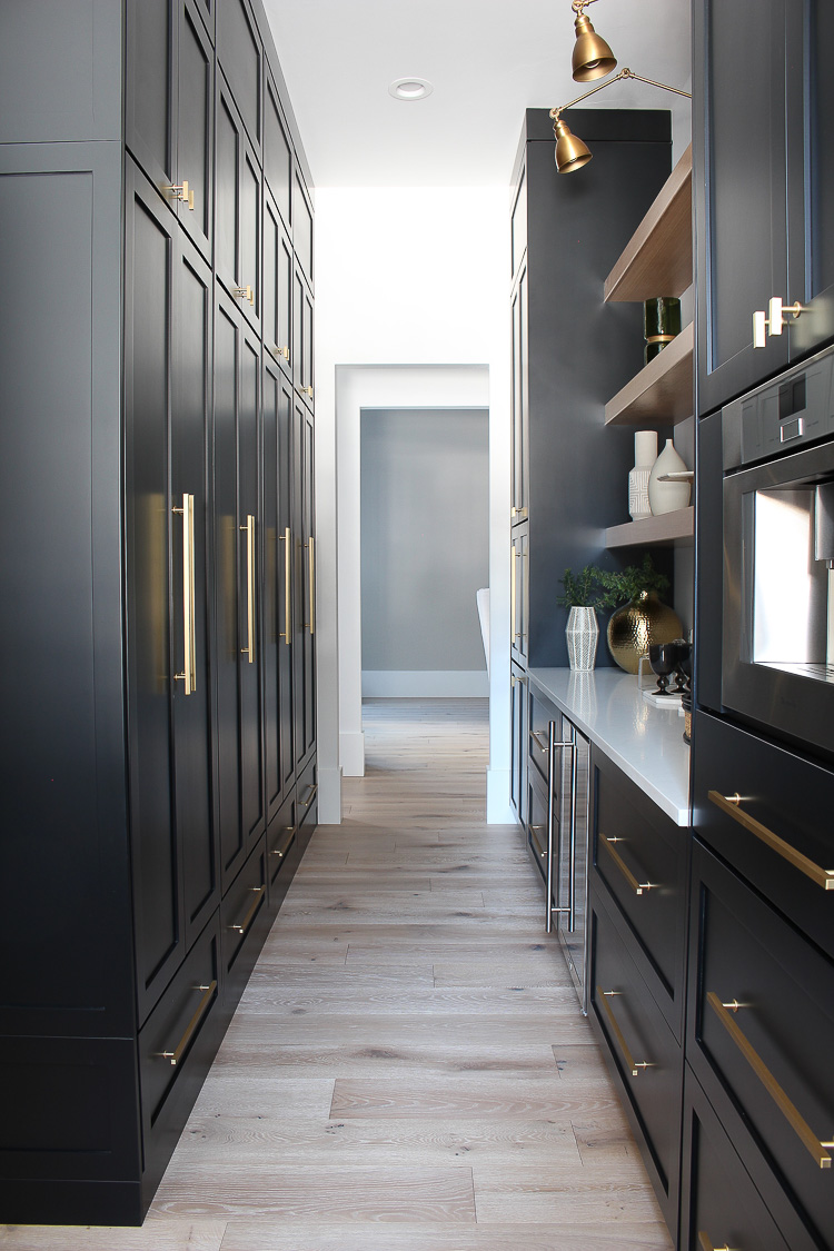 https://thehouseofsilverlining.com/wp-content/uploads/2018/11/butlers-pantry-black-cabinets-white-oak-floating-shelves-gold-hardware-marble-quartz-24.jpg