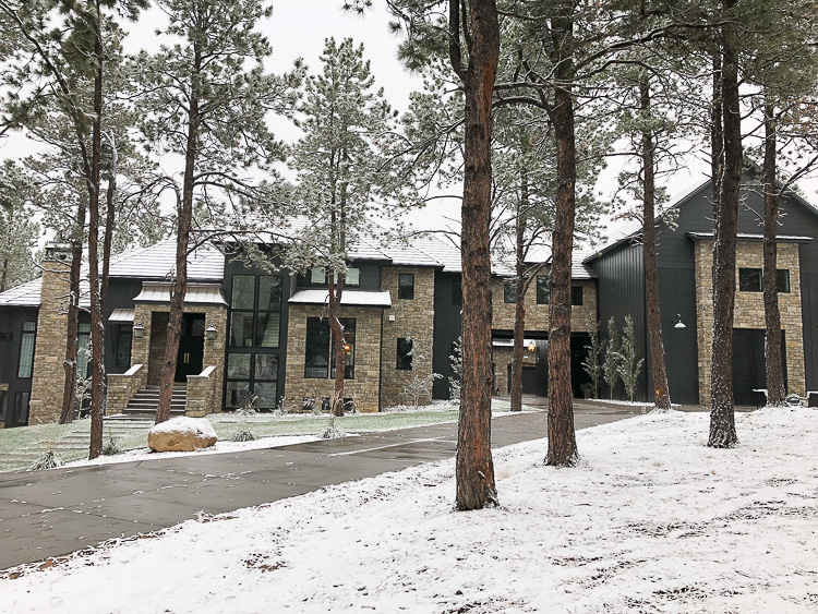 modern-chateau-black-house-european-stone-black-metal-roof-porte-cochere-forest